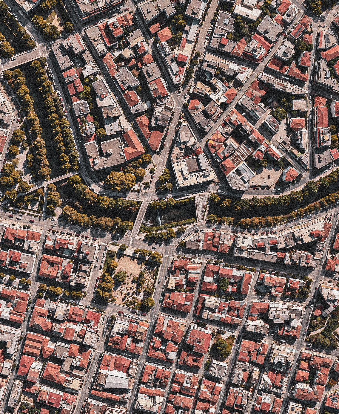 Aerial view of Trikala, with bridges crossing the river between densely packed city blocks.