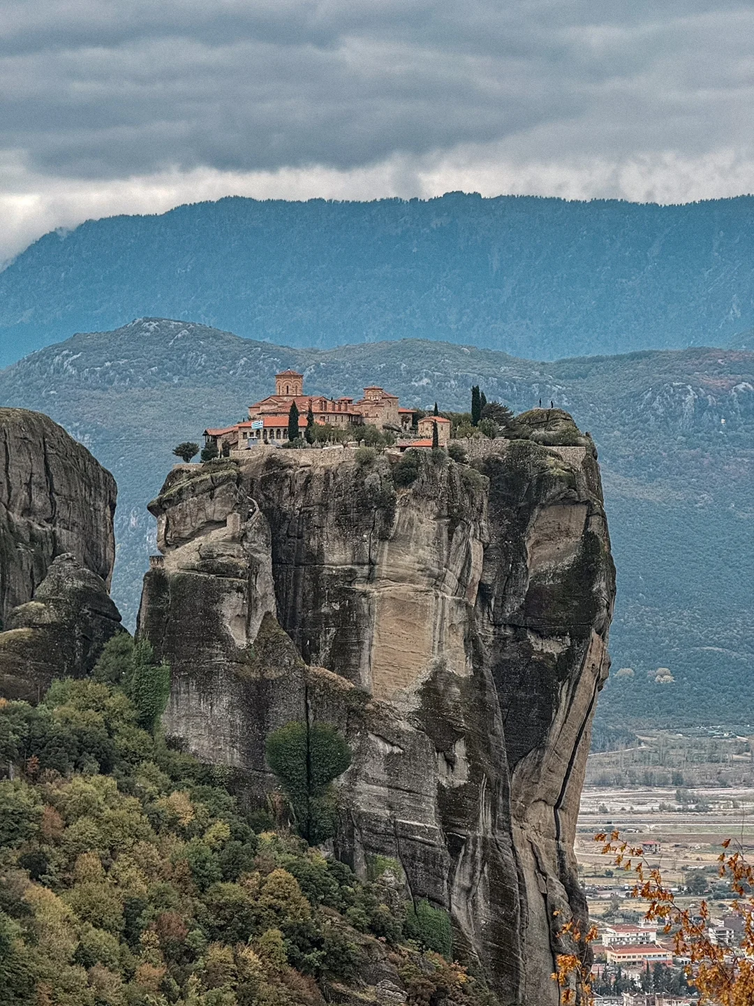 Monastery perched on an isolated rock tower above Kalampaka beneath an overcast sky.