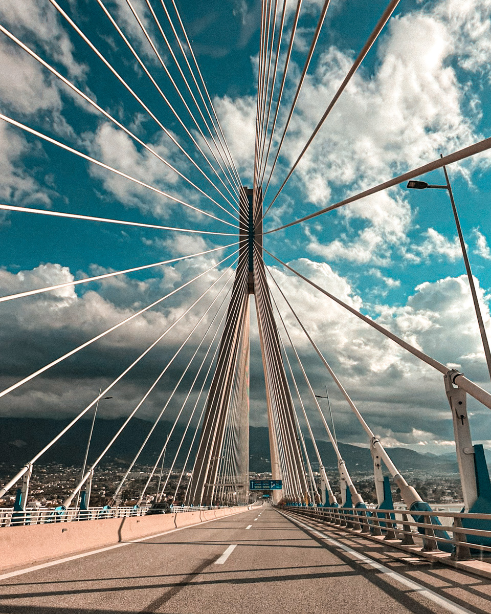 Roadway and cables of the Rio–Antirrio Bridge beneath a blue sky with scattered clouds.